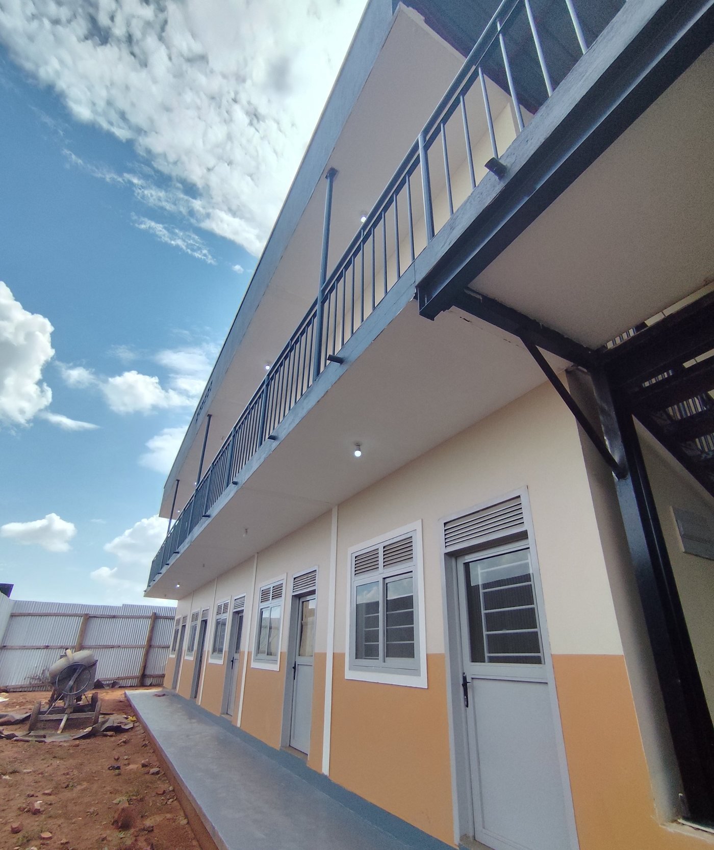 Two-storey building freshly painted in cream and orange with black steel balcony railings