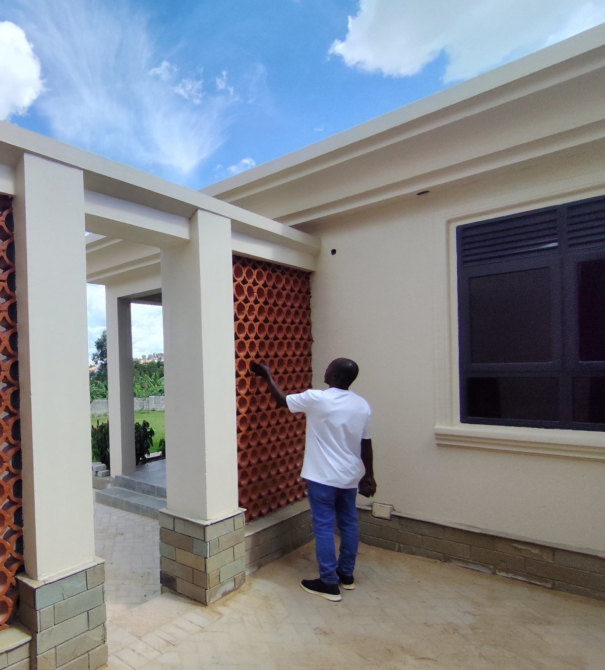Auxano team member inspecting a terracotta breeze-block wall on a finished courtyard
