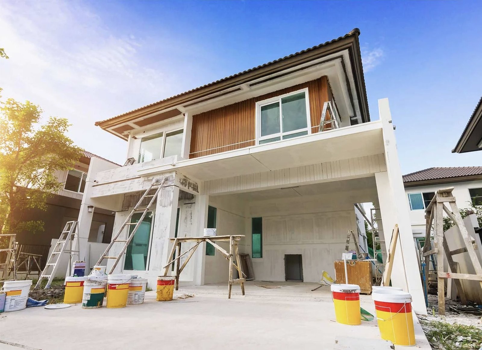 House under renovation with ladders and paint buckets in front